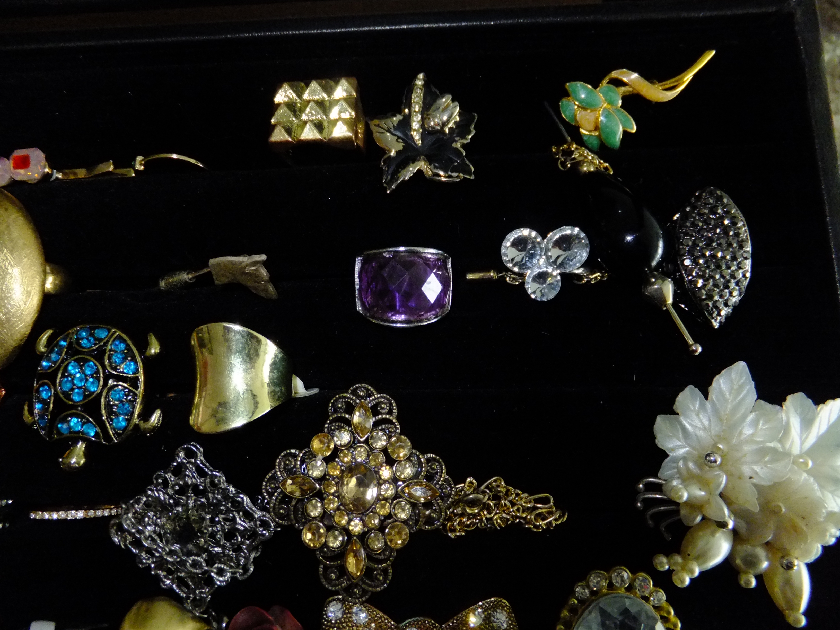 Showcase met ±50 stuks onedele sieraden – vintage en modern – ringen, broches, oorbellen